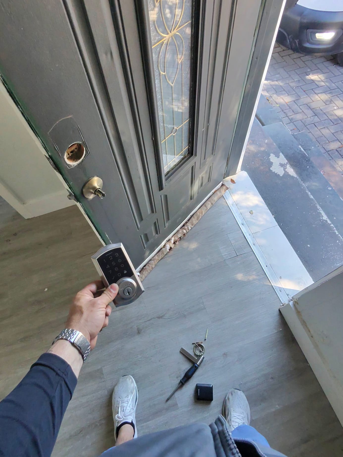 Keypad deadbolt and existing home door hardware during residential locksmith work